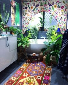 Fürdőszoba káddal, színes függönnyel, mintás szőnyeggel és növényekkel